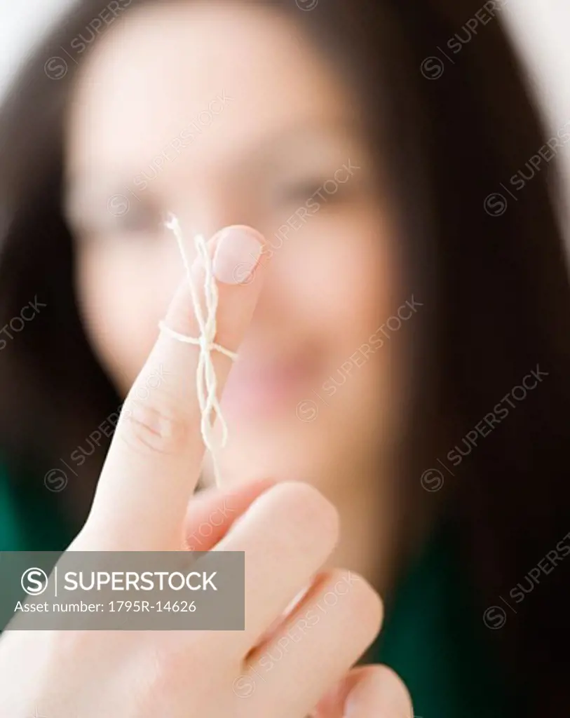 Woman with string tied around finger