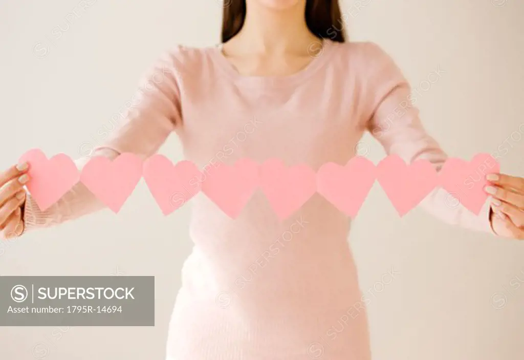 Woman holding string of cut out hearts