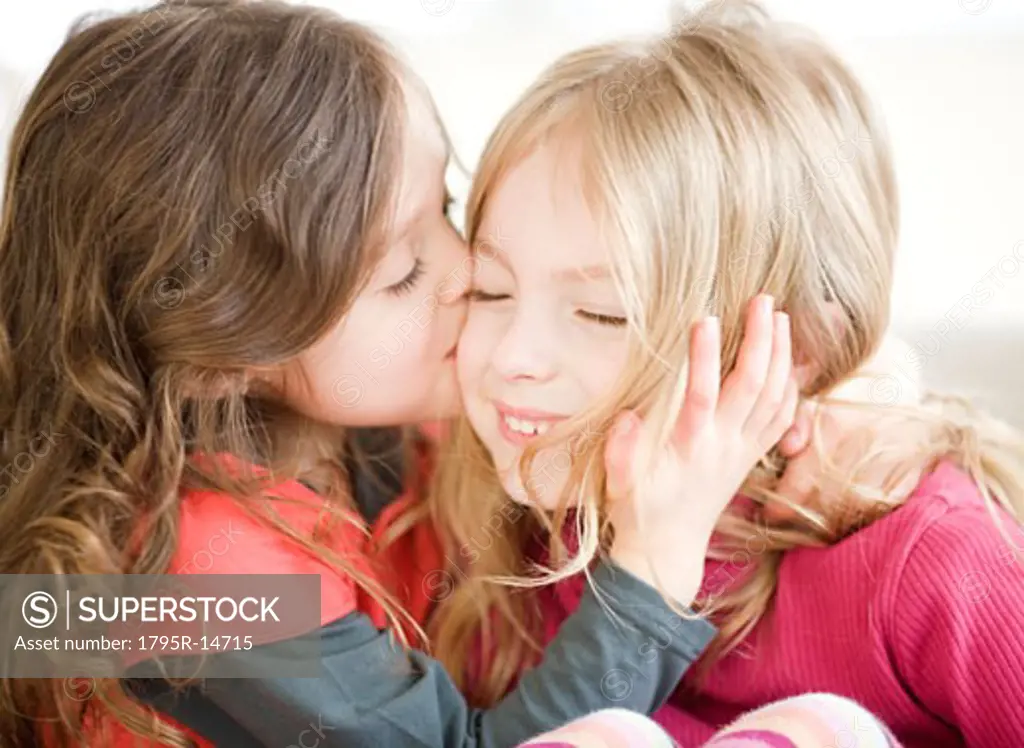 Girl kissing sister on cheek