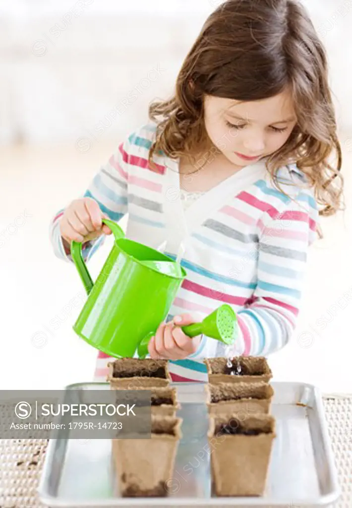 Girl watering small potted plants