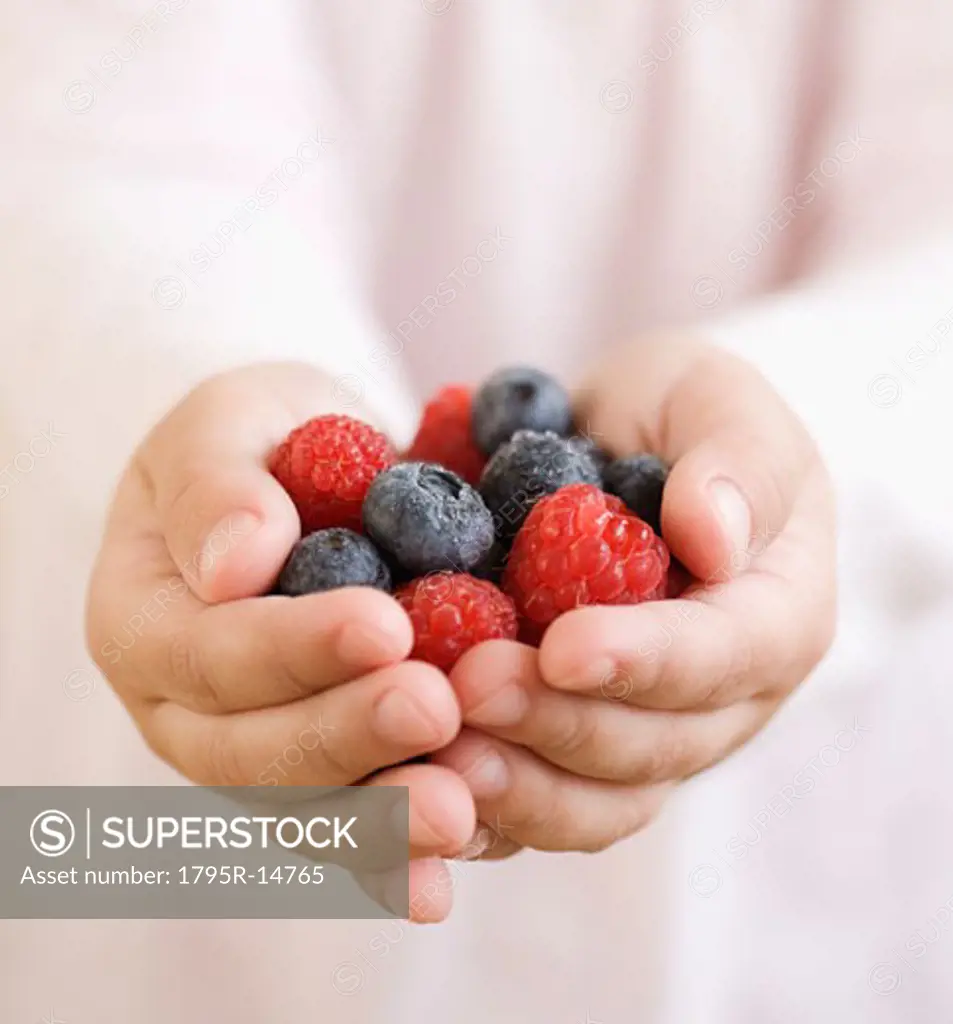 Child holding handful of berries
