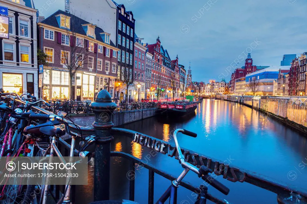 Netherlands, Amsterdam, Bicycles on bridge with canal in background