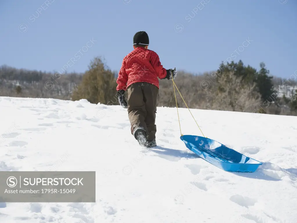 Boy pulling sled in snow