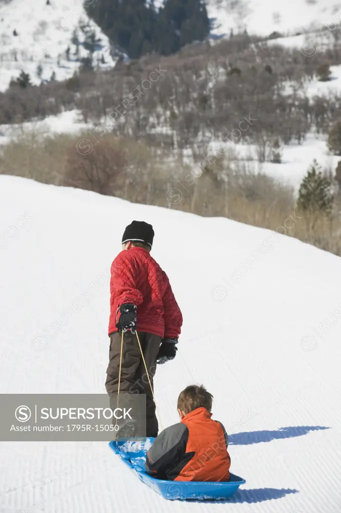 Boy pulling brother in sled