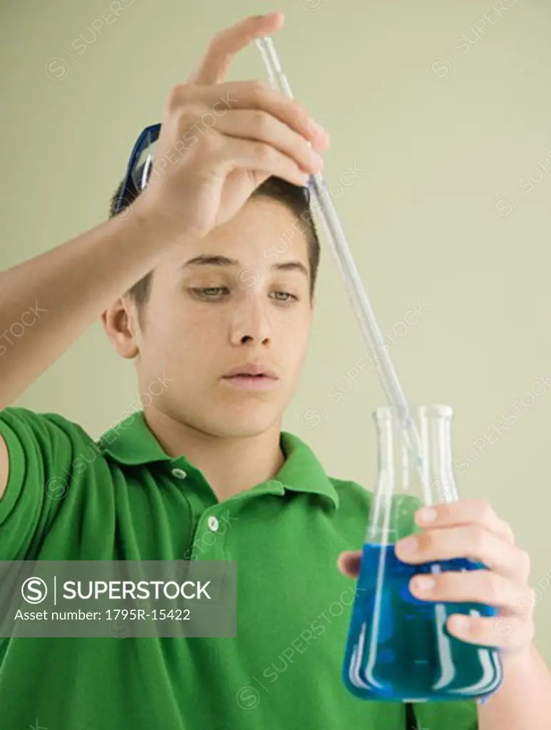 Boy measuring liquid in beaker