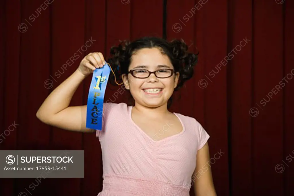 Girl holding first place ribbon on stage
