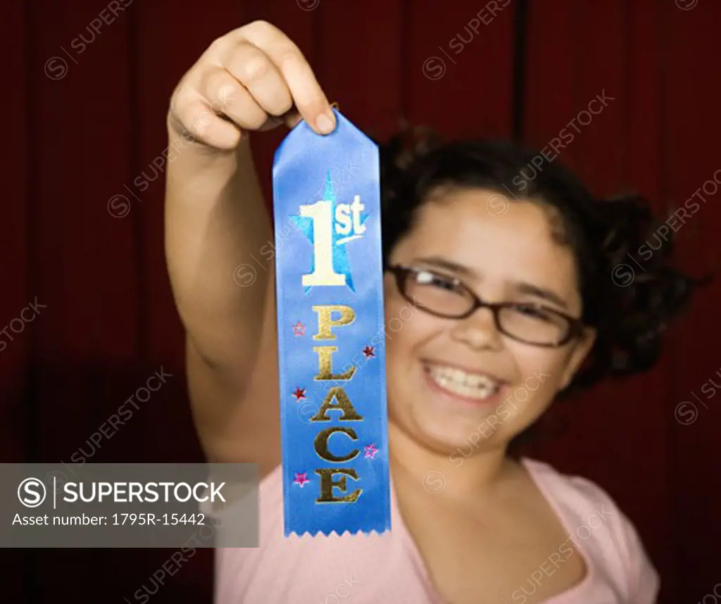 Girl holding first place ribbon on stage