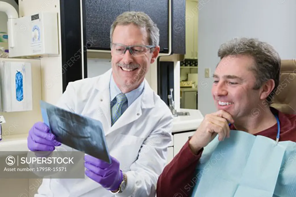 Male dentist and patient looking at x-ray