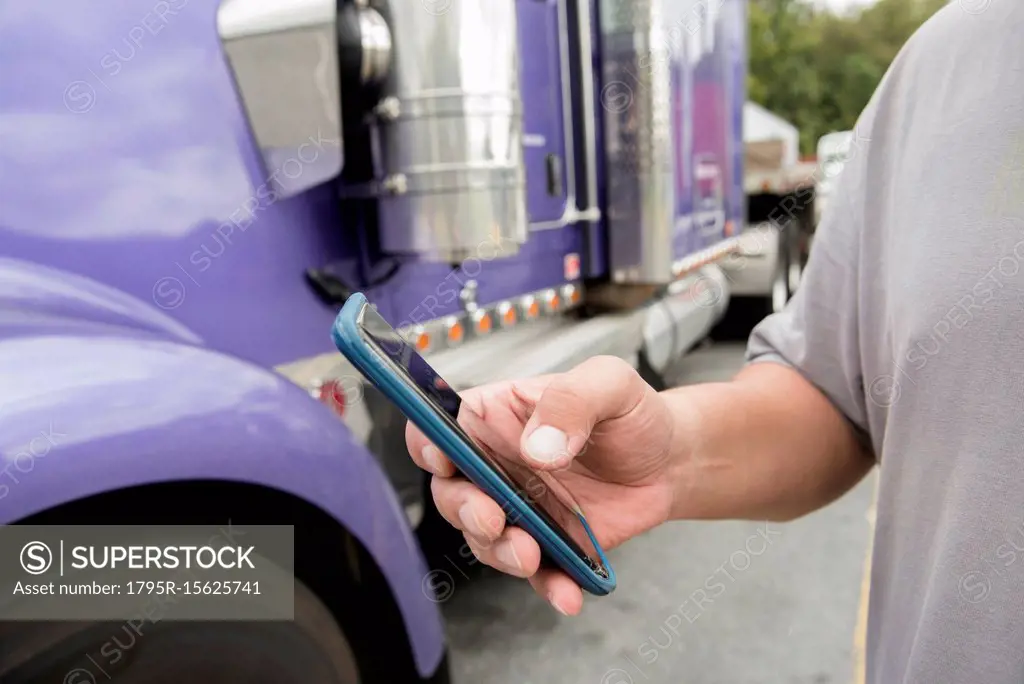 Hand of truck driver using smart phone