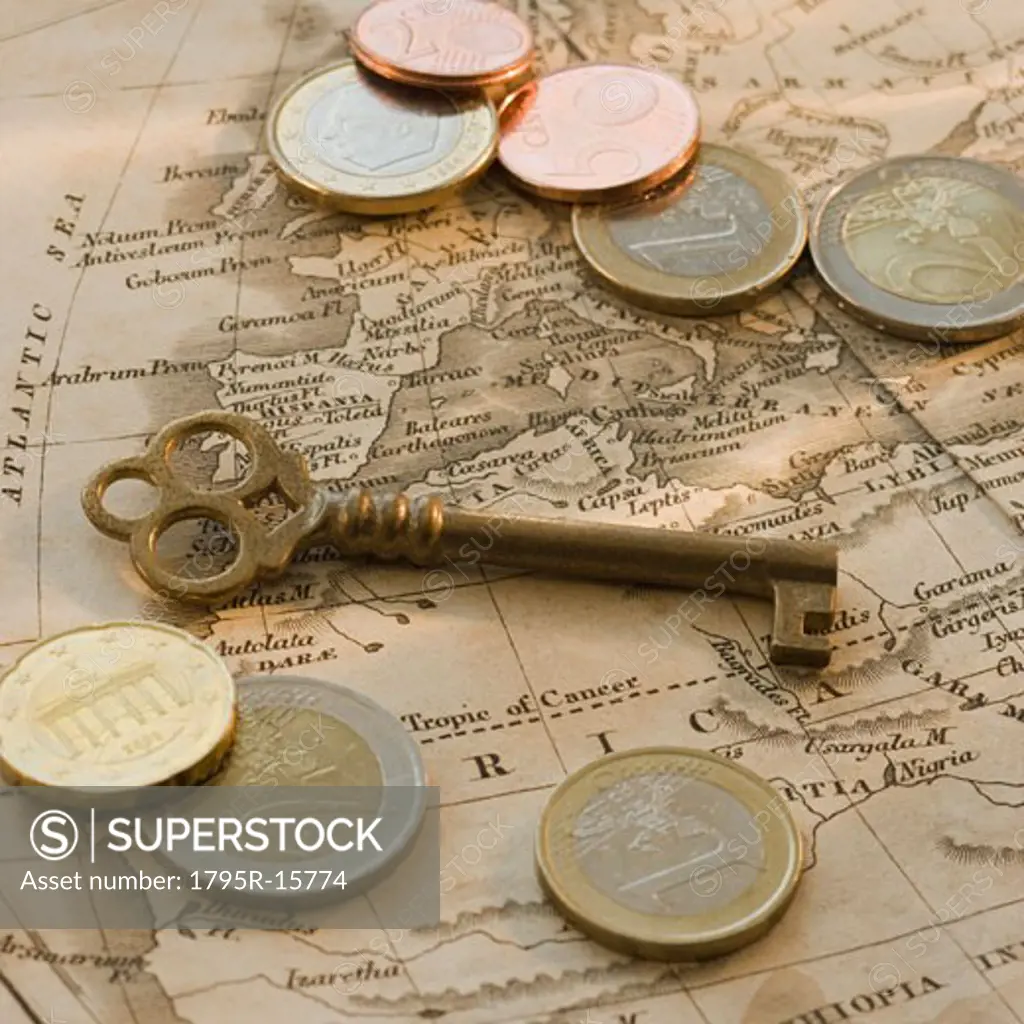 Close-up of euro coins, map and antique key