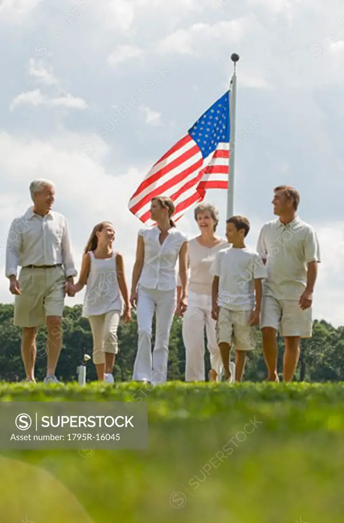 Multi-generational family walking in front of American flag