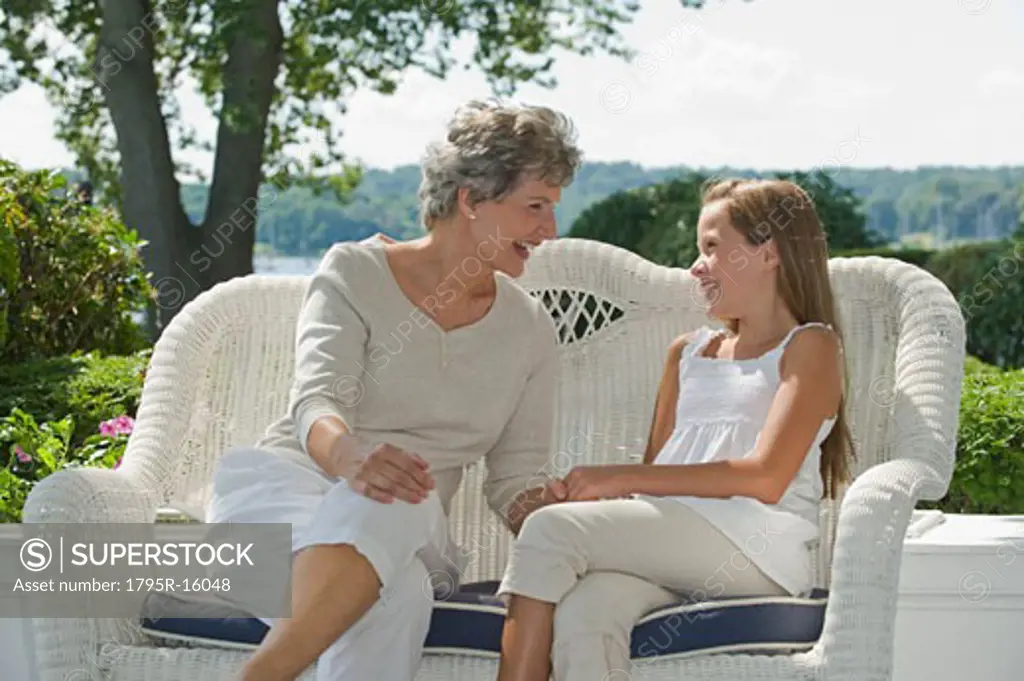 Grandmother and granddaughter sitting on porch