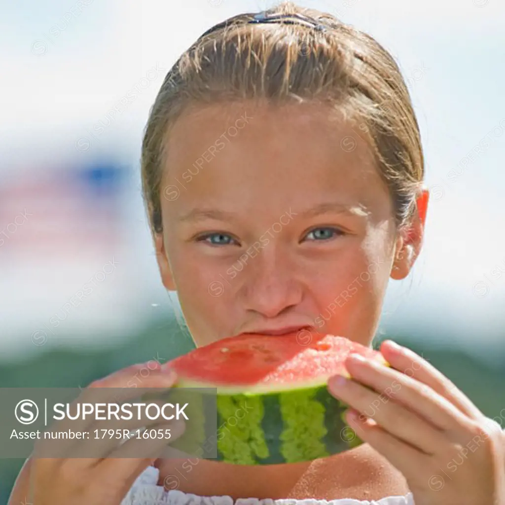 Girl eating watermelon outdoors