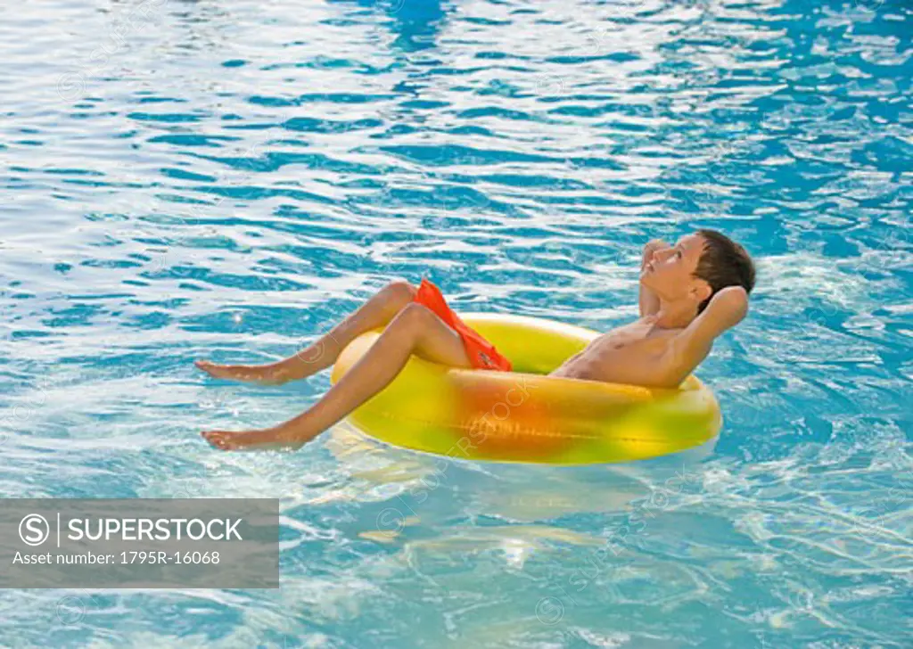 Boy relaxing in inflatable tube in swimming pool