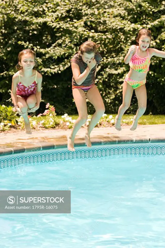 Girls jumping into swimming pool