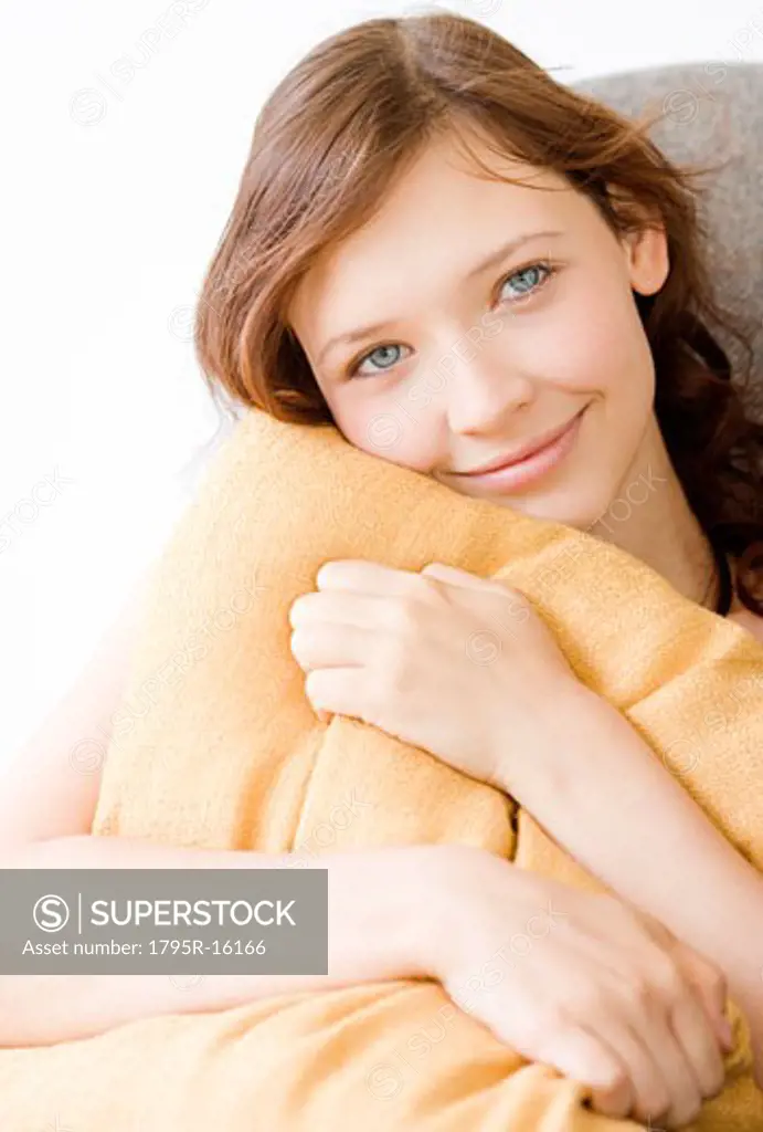 Teenage girl hugging pillow
