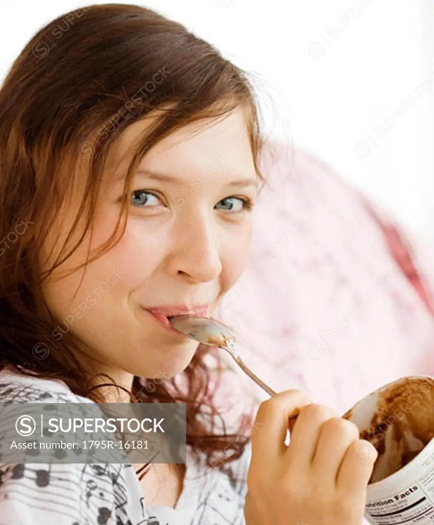 Teenage girl eating from ice cream carton