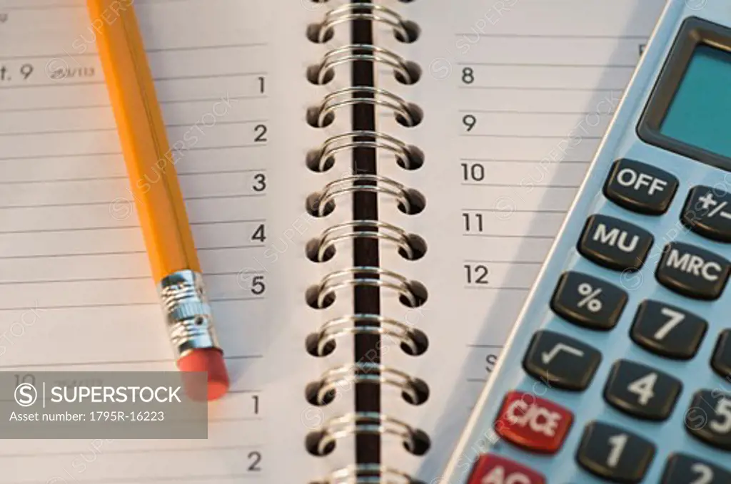 Close-up of pencil, notebook and calculator