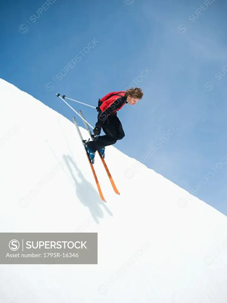 Skier dropping in to half-pipe