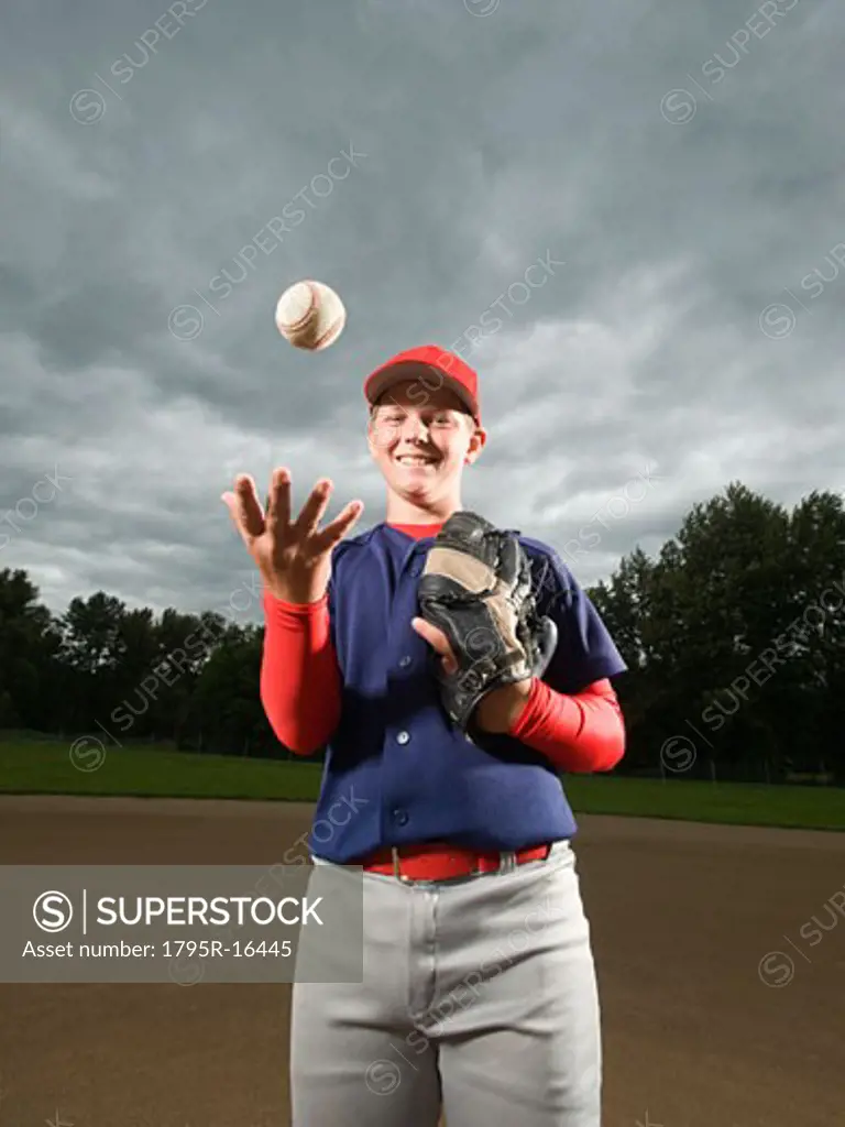 Baseball pitcher tossing ball in air