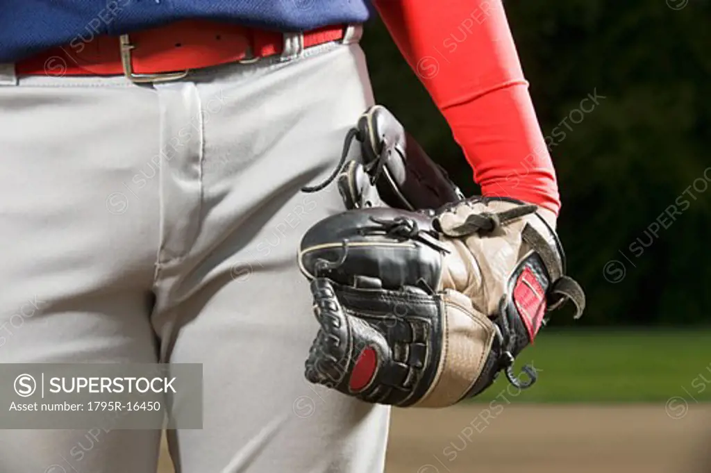 Baseball player holding mitt at side
