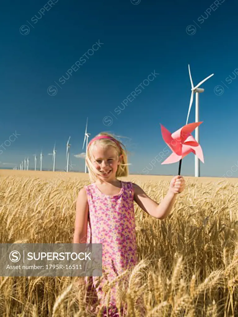 Girl holding pinwheel on wind farm