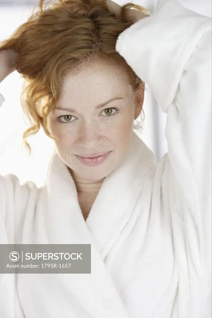 Woman in bathrobe holding hair up