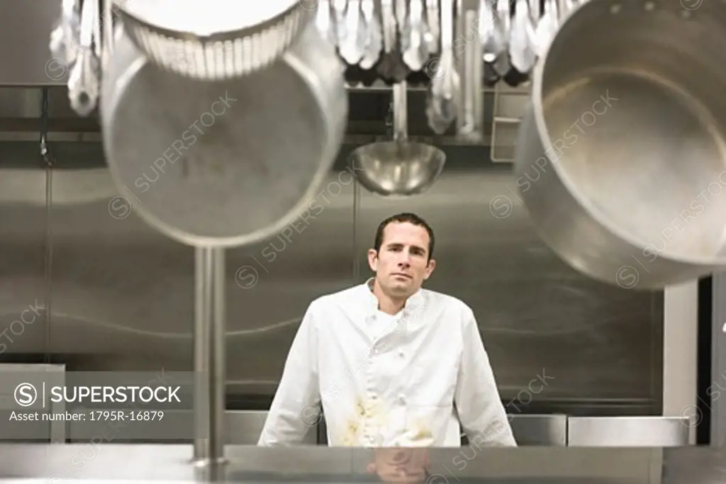Dirty chef leaning against stove