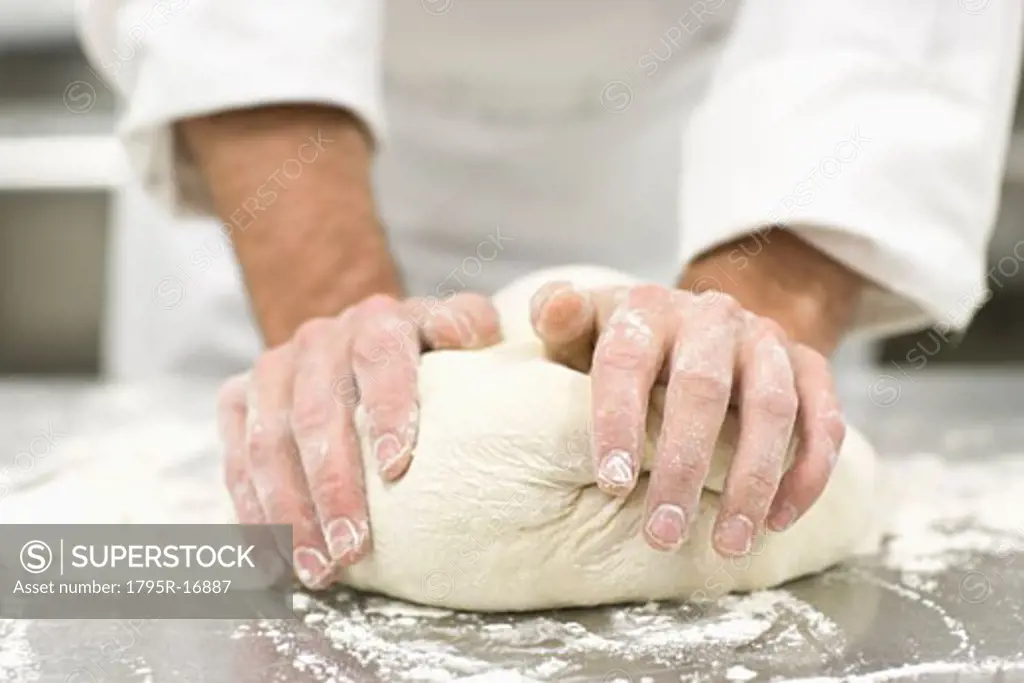 Baker kneading bread dough