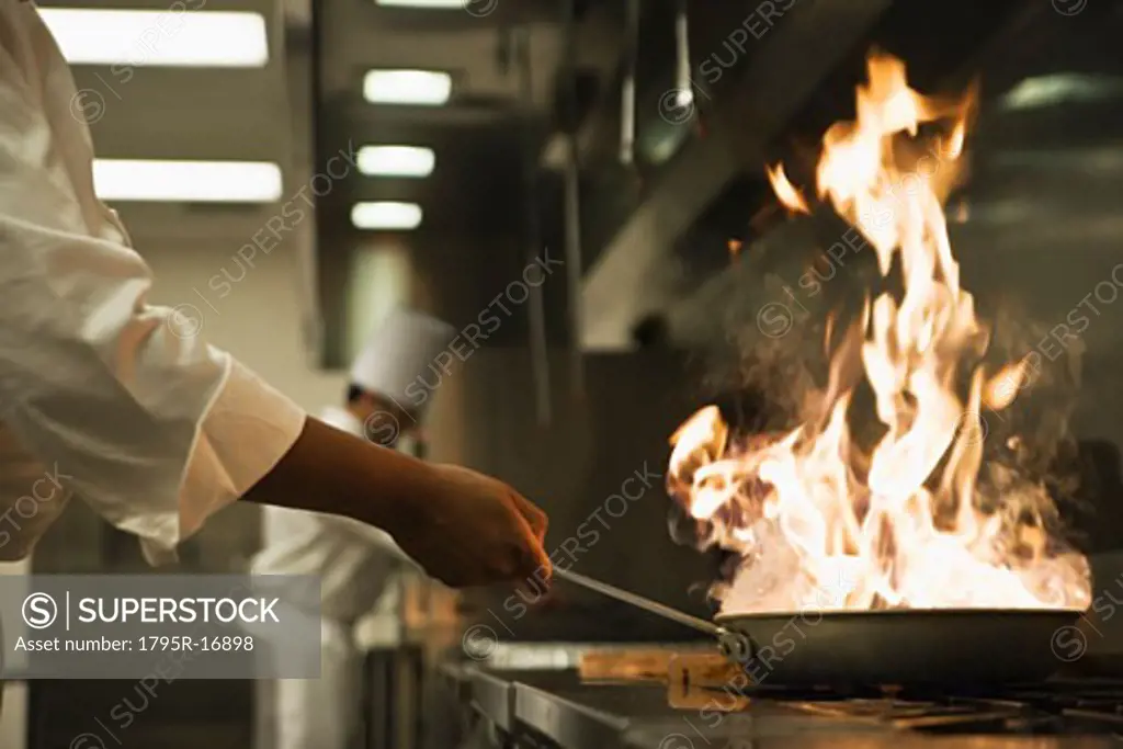 Chef holding flaming pan