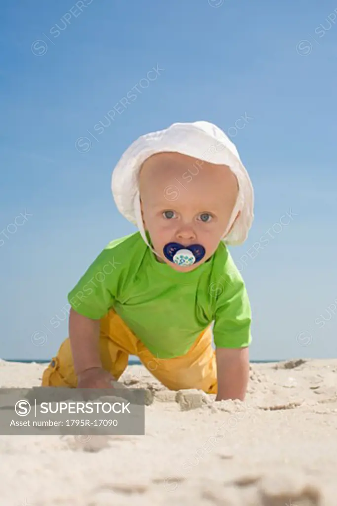 Baby boy crawling on beach