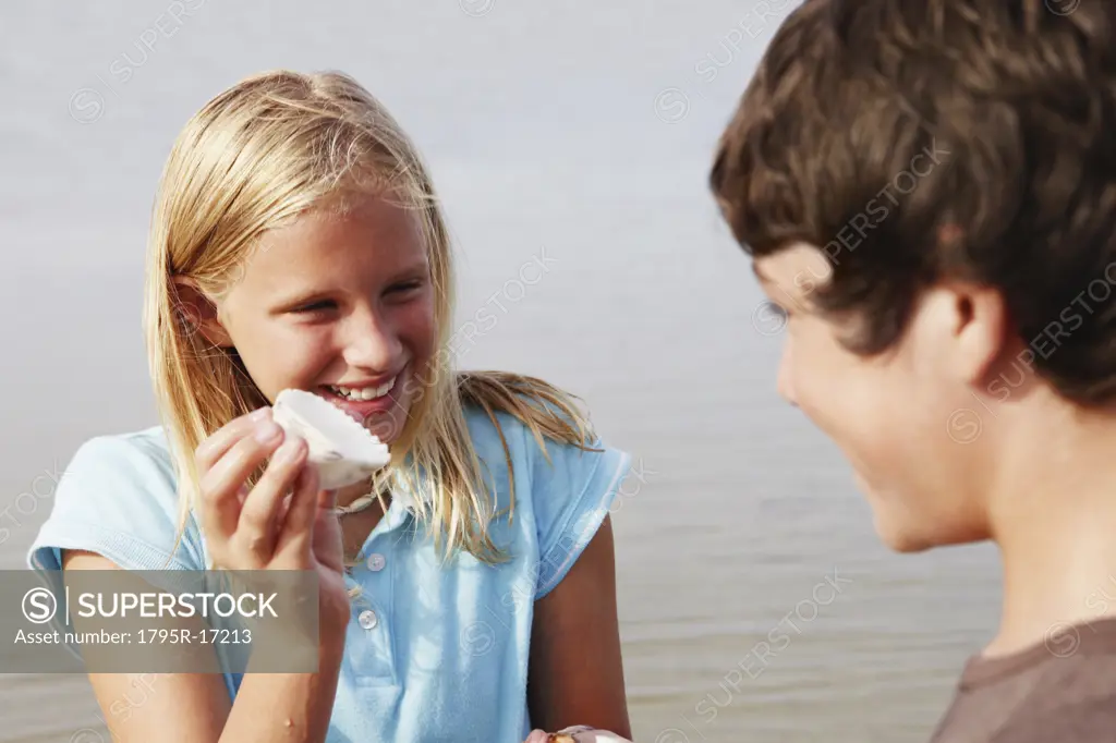 Girl showing shell to friend