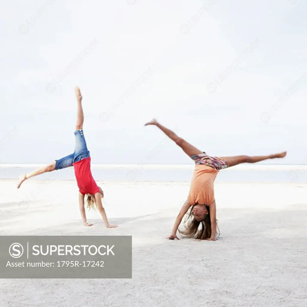 Girls doing cartwheels on beach