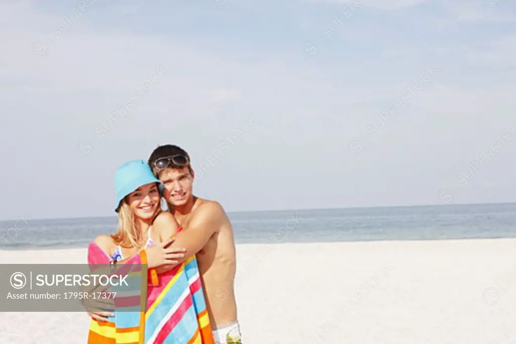 Teenage couple hugging on beach
