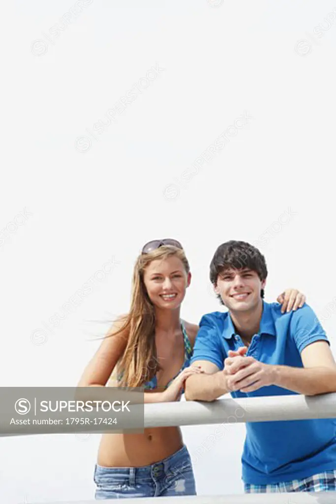 Young couple leaning on boardwalk railing