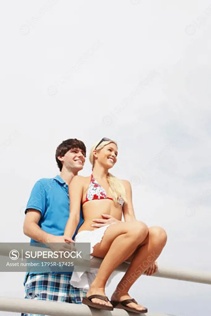 Young couple hugging on boardwalk railing