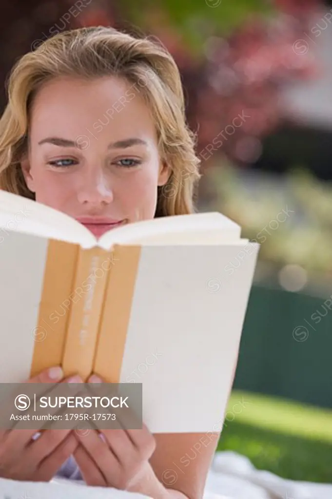 Woman reading book outdoors