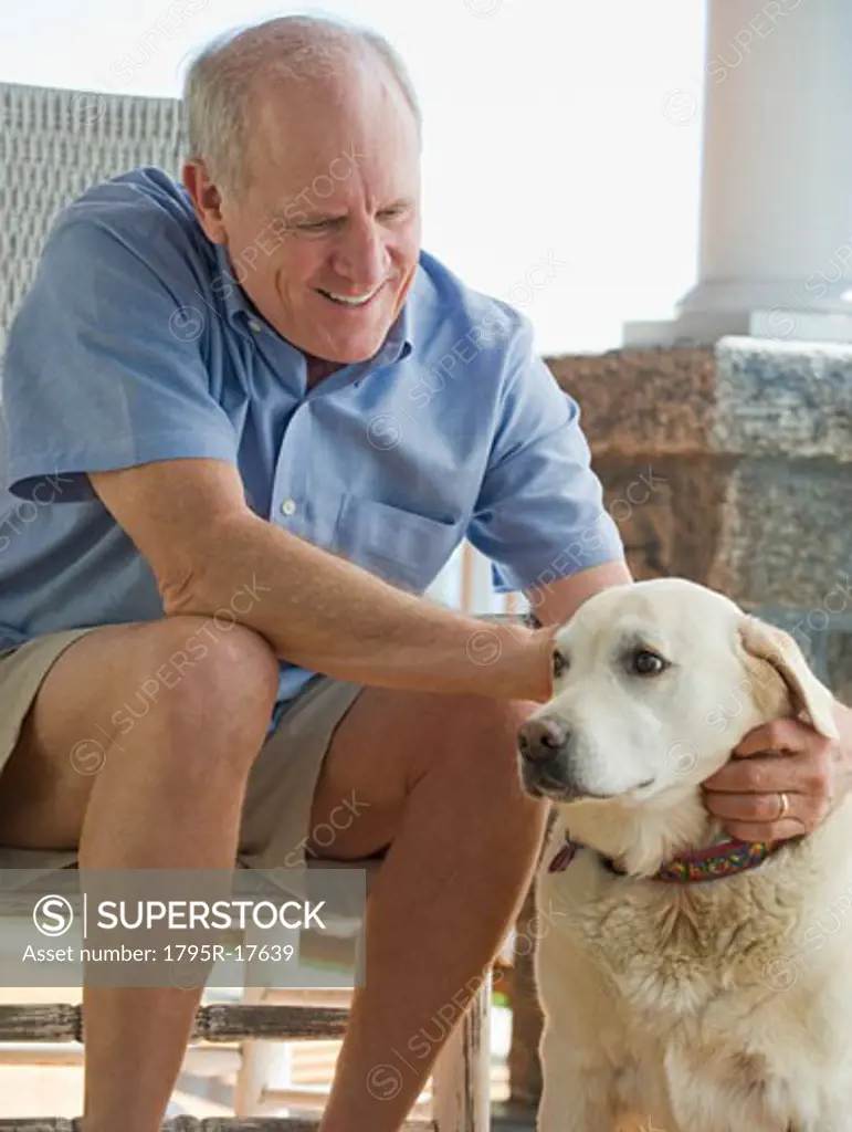 Senior man sitting on porch with dog