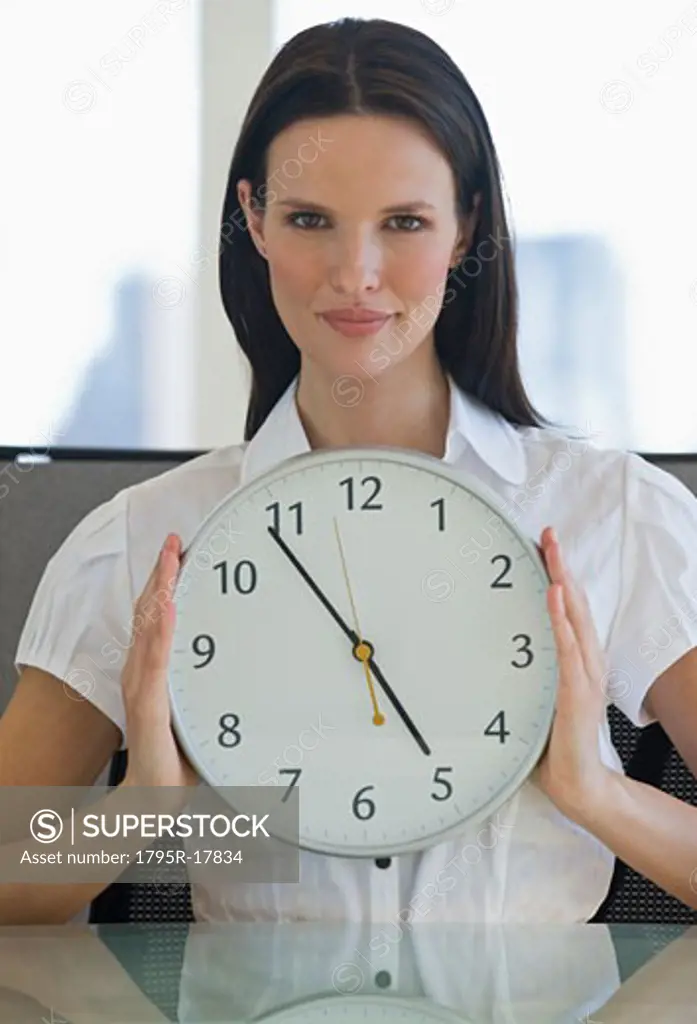 Portrait of businesswoman holding clock