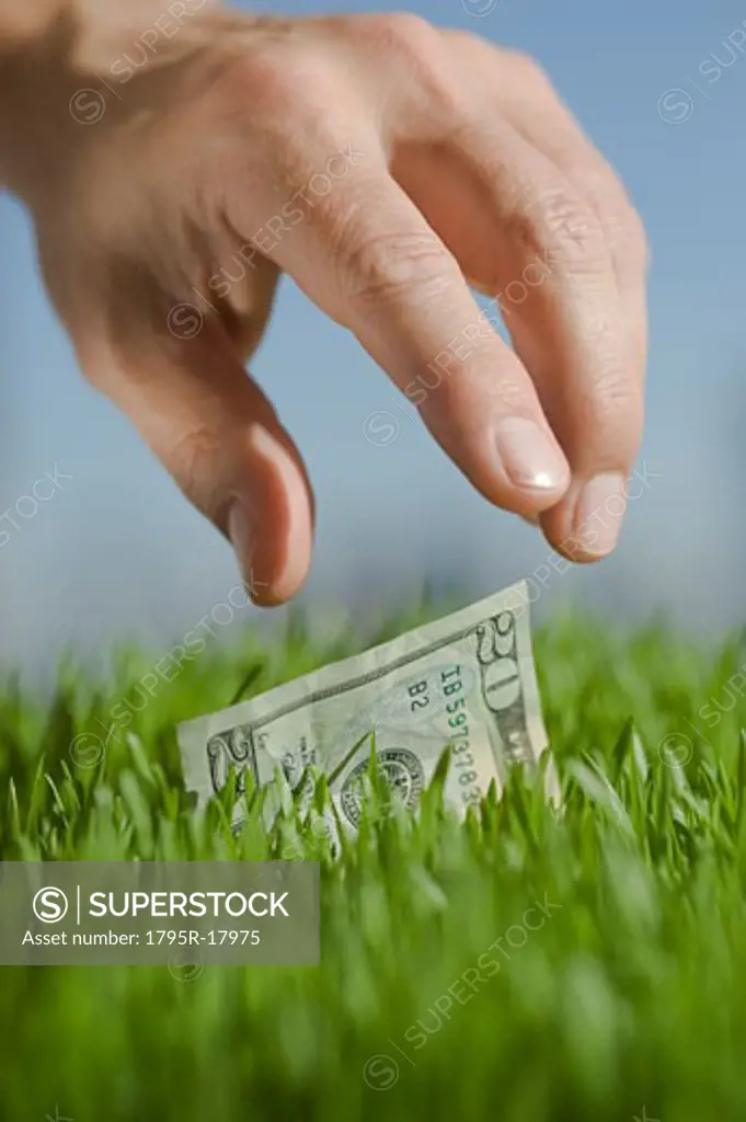 Close-up of hand reaching for twenty dollar bill