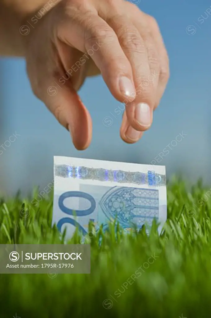 Close-up of hand reaching for twenty euro bill