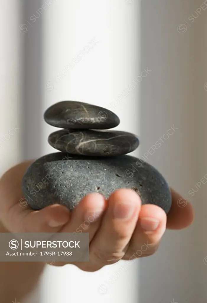 Close-up of hand holding three stones