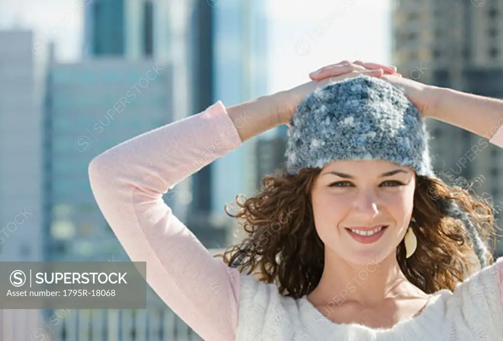 Portrait of woman in stocking cap with city in background