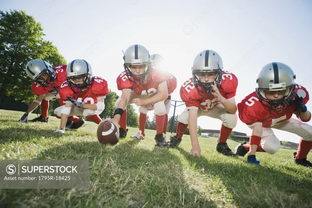 Football players at line of scrimmage ready to snap football