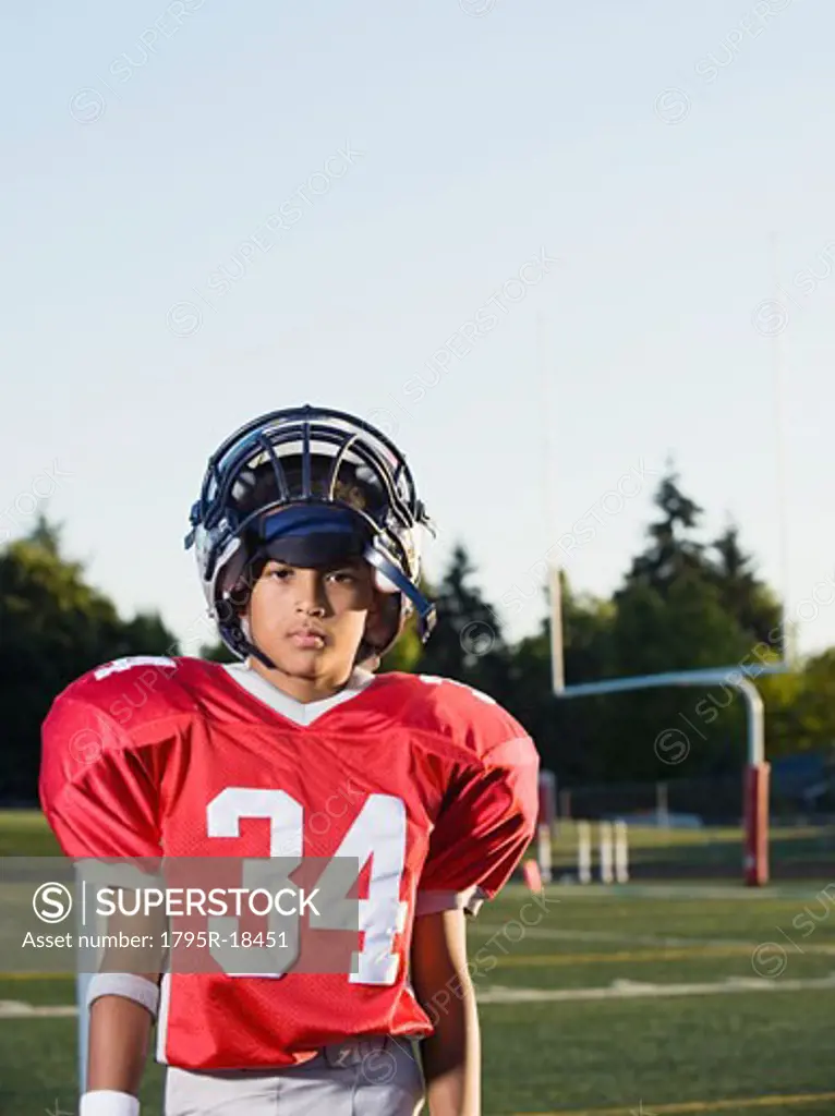 Football player standing on field and looking serious
