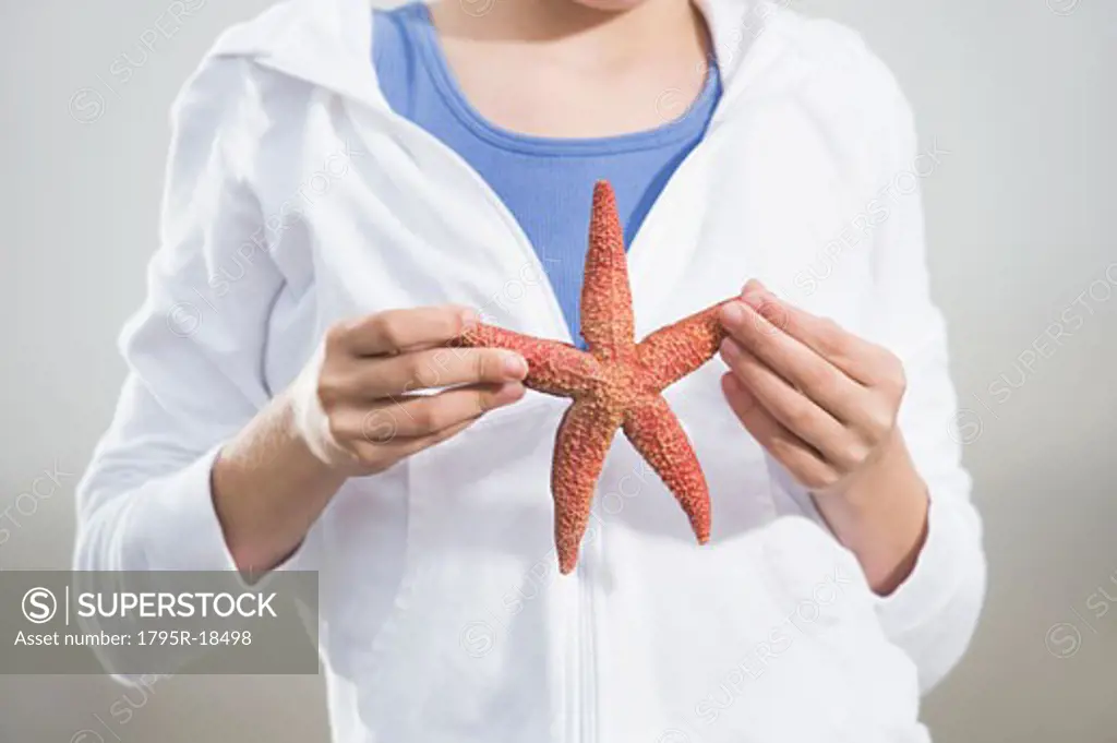 Portrait of girl holding starfish