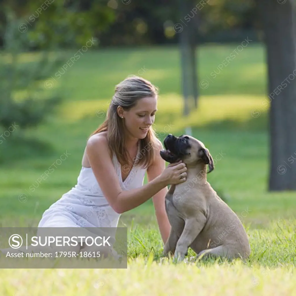 Woman petting dog in park