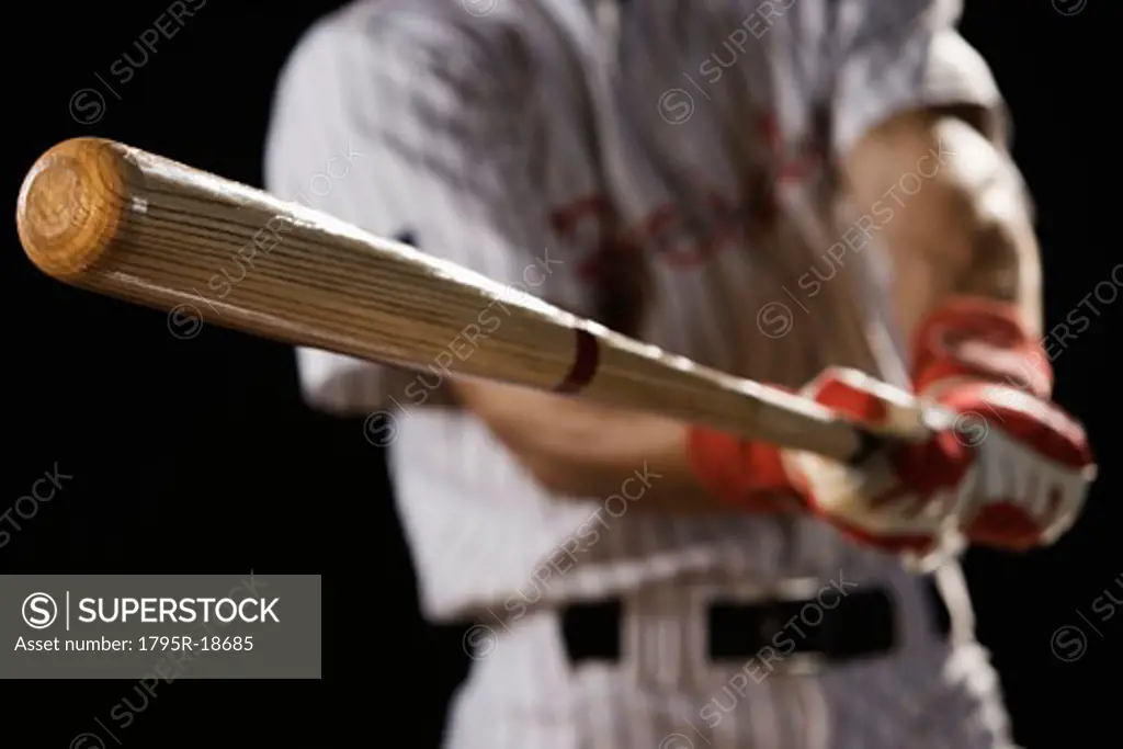 Close-up of baseball player swinging bat