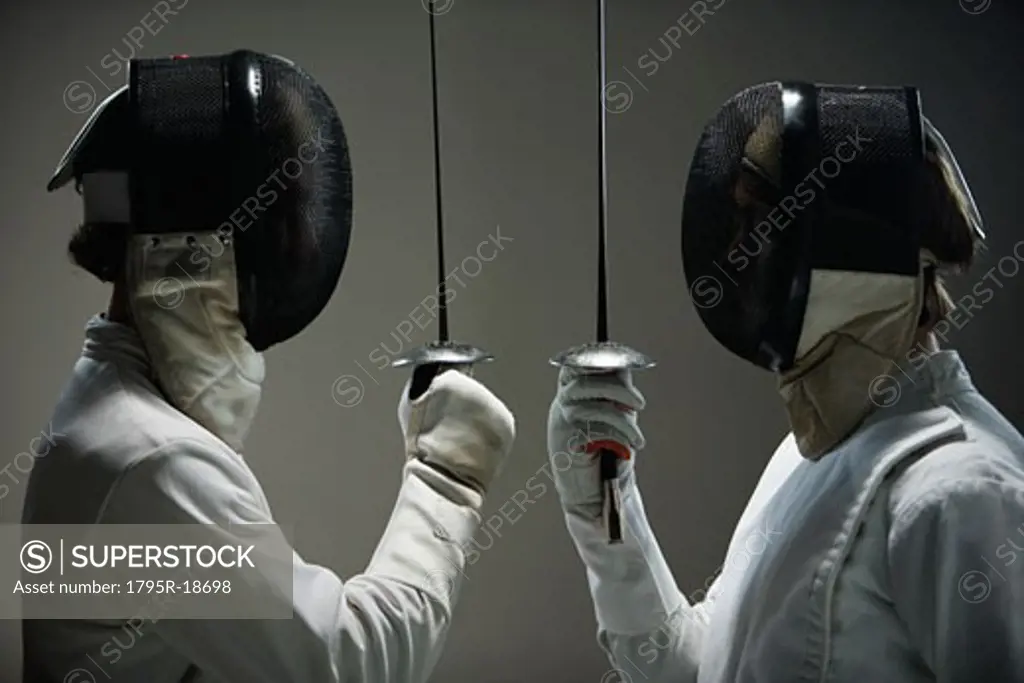Fencers in masks facing off with fencing foils