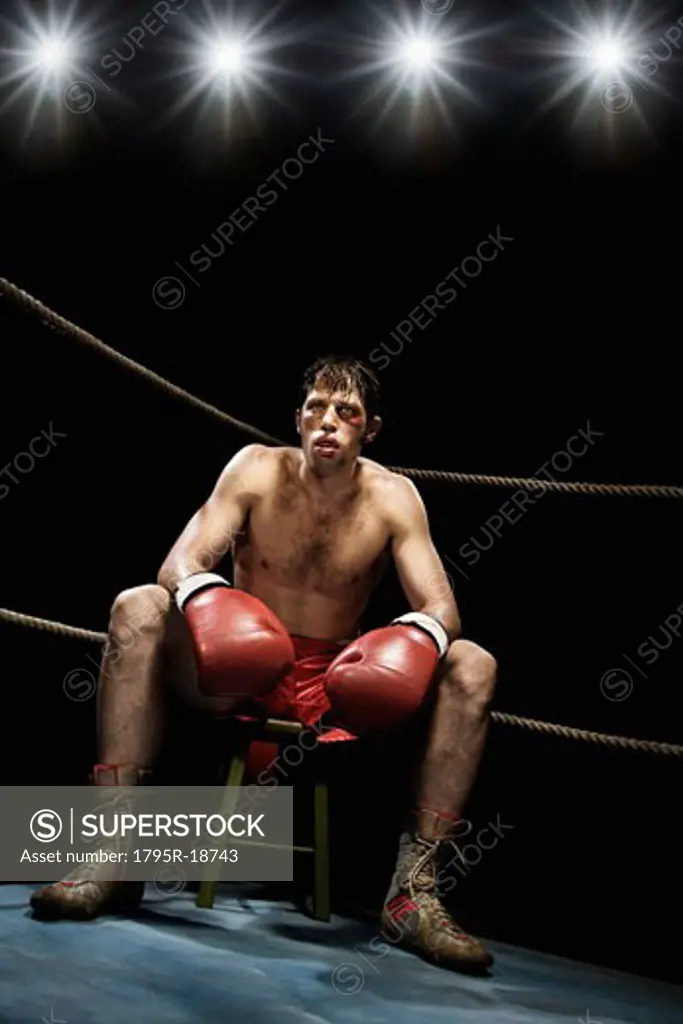 Boxer sitting on stool in corner of boxing ring